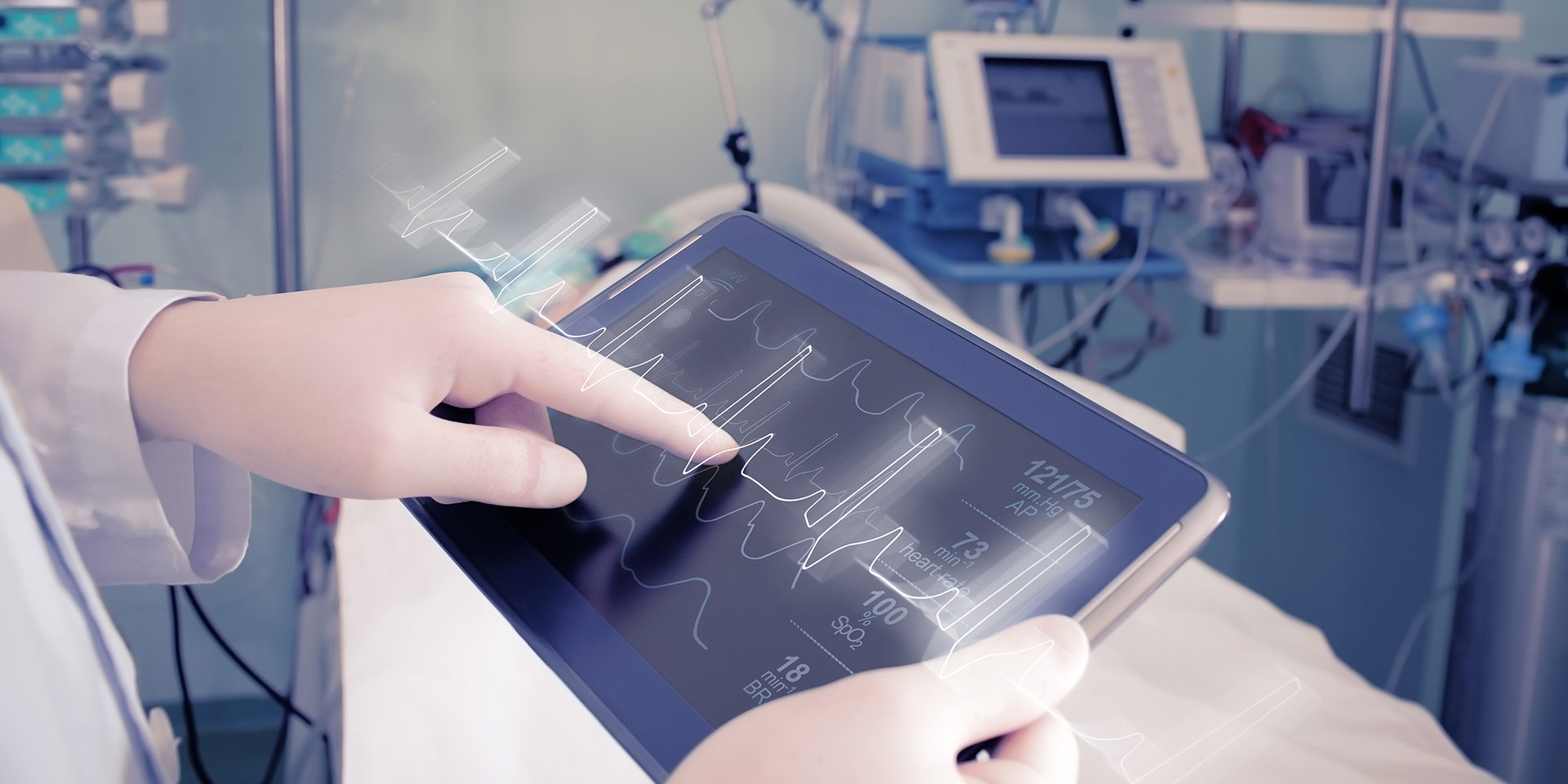 A person holding a tablet displaying an electrocardiogram