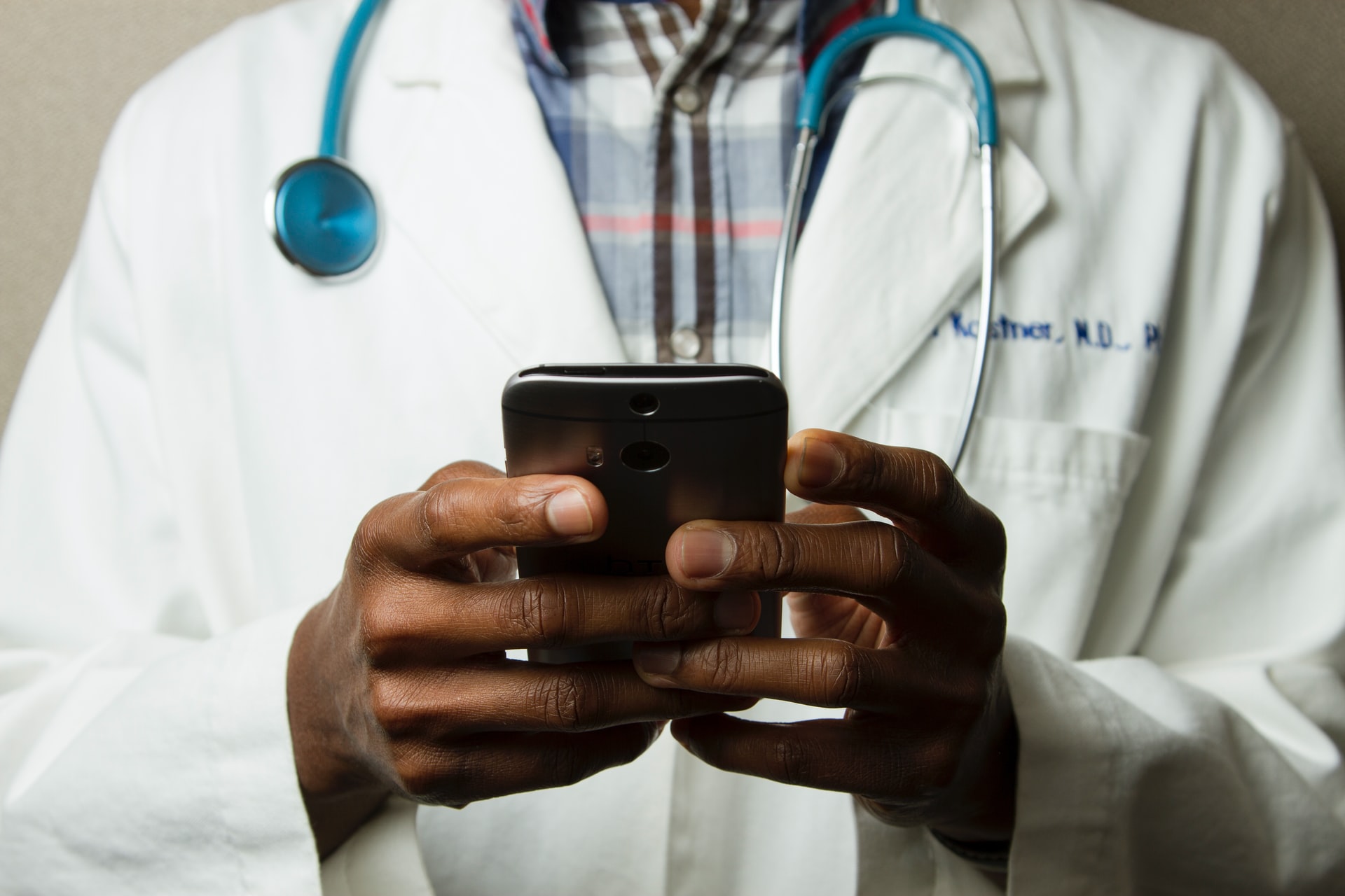 A person holding a tablet displaying an electrocardiogram